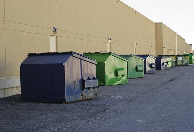 a row of blue construction dumpsters on a job site in Englishtown